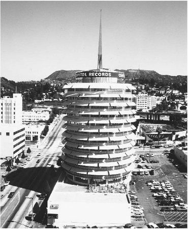 The Capitol Records building stands near Los Angeless famous Hollywood sign.