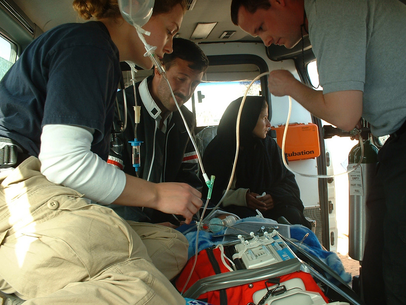 IMSuRT staff transport two sick children to a waiting ambulance. Photo...