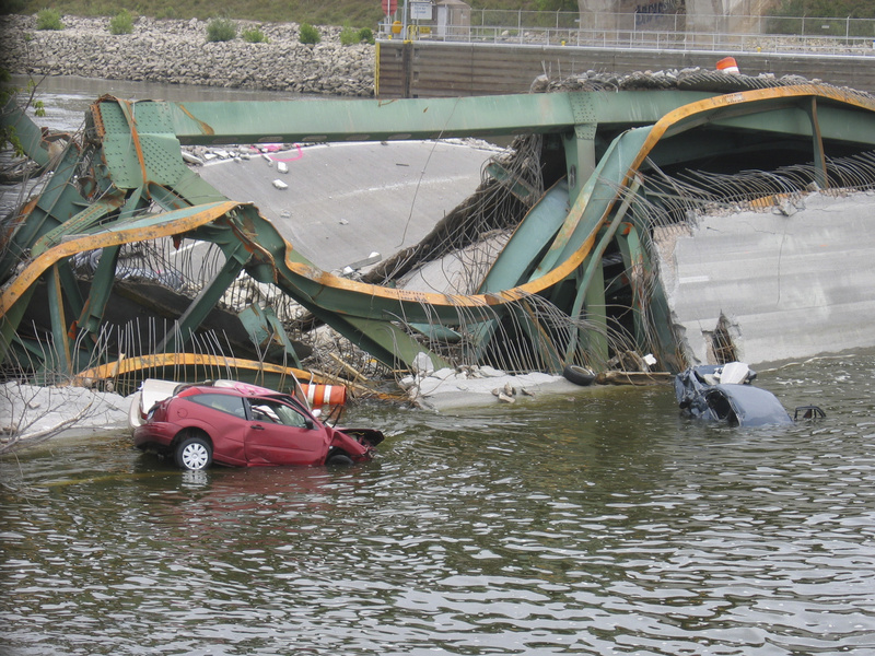 Cars and roadway litter the river where the I-35 bridge collapsed in Minneapolis....