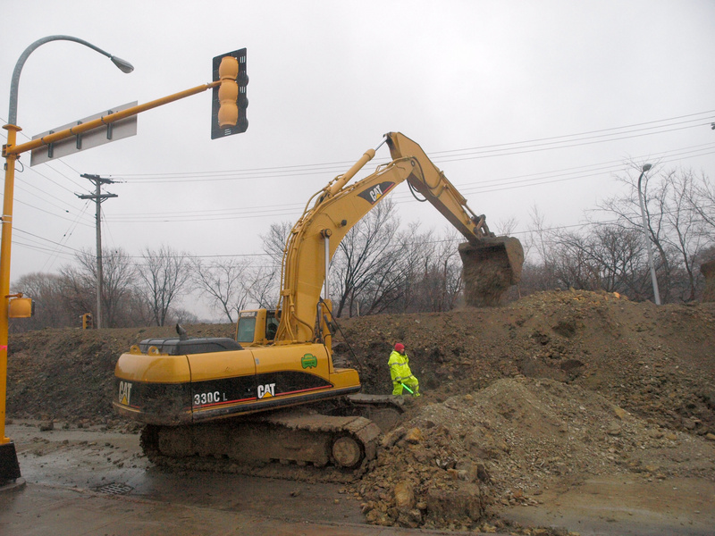 Workers along 2ND Street Fargo work to raise the height of a clay dike...
