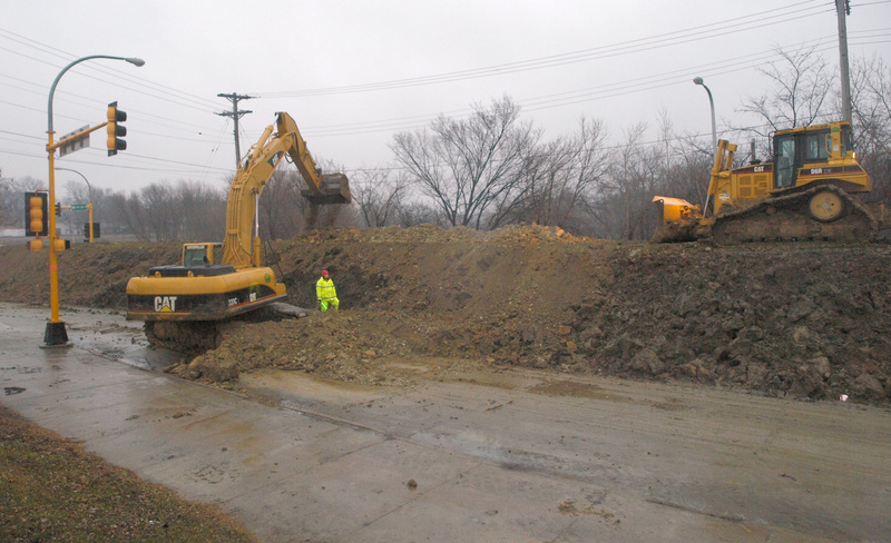 Workers along 2ND Street Fargo work to raise the height of a clay dike...