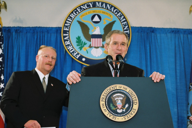 Washington: President Bush jokes with FEMA Director Joe M. Allbaugh before...