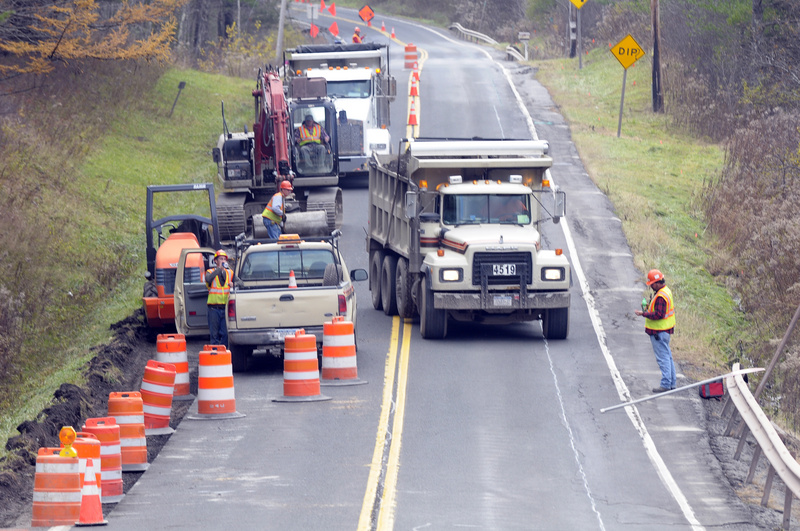 Repair crews replace a section of Route 30 in Gilboa, N.Y., after being...