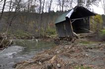 A battered Bowers Bridge rests atop an embankment along Mill Brook in...