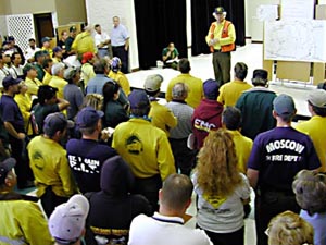 Loveland: Firefighters listen to evening briefing after a long day on...